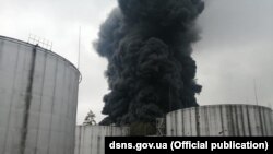 На фото і відео, оприлюднених рятувальниками з місця події, видно, як густий чорний дим здіймається над резервуарами з пальним