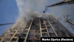 Пожежники гасять вогонь, спричинений обстрілом РФ, у багатоповерхівці в Києві, 15 березня 2022 року
