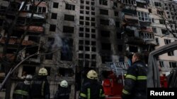 یوشمېر اوروژونکي له کییف سره نېږدې په یوه سیمه کې د برید ښکار شوې رهایشي ودانۍ معاینه کوي - د مارچ ۱۴مې انځور.