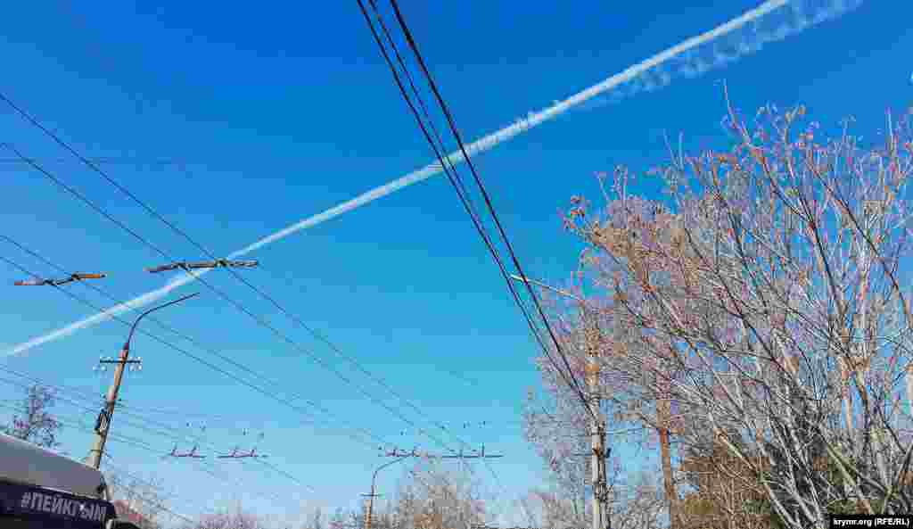 Инверсионный след от военного самолета. Как сообщил корреспондент Крым.Реалии, «характерный гул в небе от пролета транспортников жители крымской столицы периодически в течение суток слышат начиная с 24 февраля 2022 года». С аннексированного Крыма на материковую часть Украины поступает военная техника и личный состав российской армии, который принимает участие в боевых действиях на юге страны