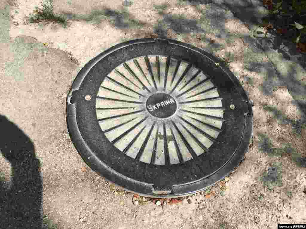 Крышка люка с надписью «Україна» на дороге в Севастополе