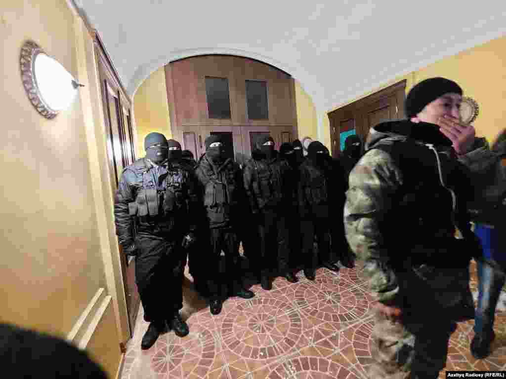 Law enforcement officers guarding a government building in the early morning of January 5. In a video address to the nation on January 4, Kazakh President Qasym-Zhomart Toqaev said the government would not fall and called for “mutual trust and dialogue rather than conflict."