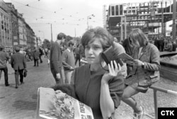 Прага, 1968 рік, радянська окупація і придушення «Празької весни». Люди на вулицях слухають радіо. Справа видно каркас будівлі майбутнього федерального парламенту Чехословаччини, в якому в 1995 році розташується Радіо Свобода