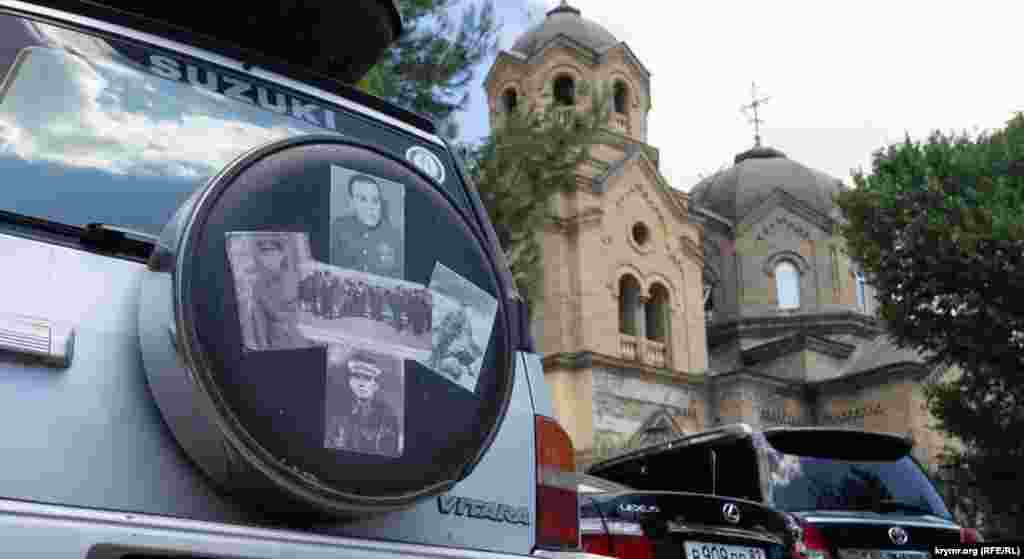 Импровизированный «Бессмертный полк» на запасном колесе иномарки перед Свято-Ильинским православным храмом