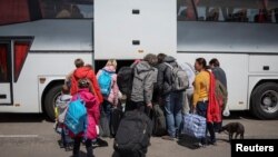 Українські біженці з Маріуполя сідають в автобус, що прямує до Польщі. Запоріжжя, Україна, 17 травня 2022 року