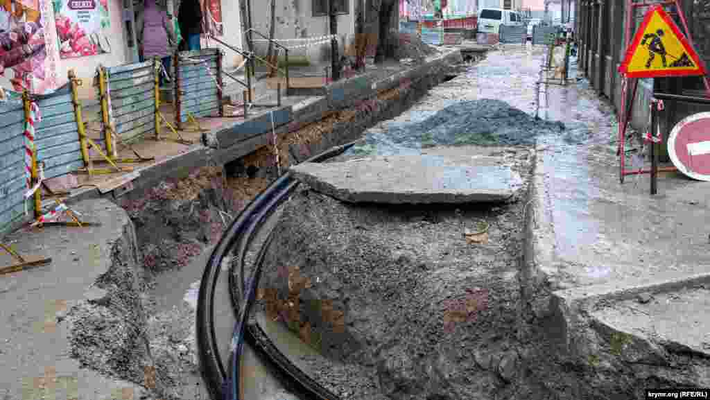 Работники «Крымтеплоэнерго» вторую неделю под дождем и мокрым снегом ремонтируют теплотрассу у рынка «Киевский ряд» (его забор справа). По словам одного из тепловиков, подобный ремонт там же проводился в 2017 и 2021 годах