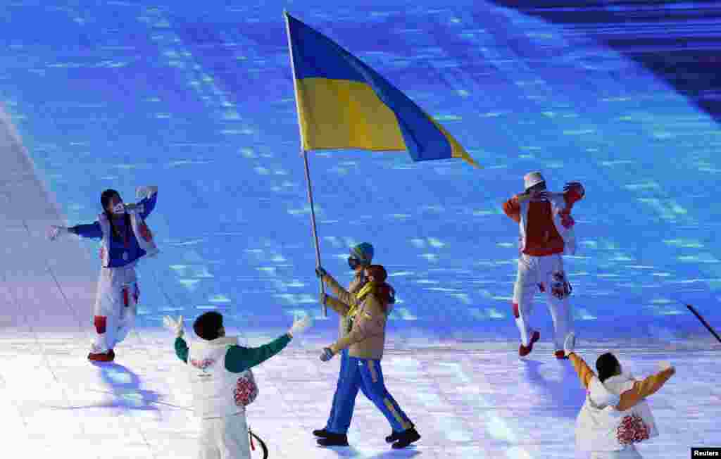 Українські прапороносці Олександра Назарова та Олександр Абраменко під час церемонії відкриття зимових Олімпійських ігор 2022 у Пекіні, Китай, 4 лютого 2022 року