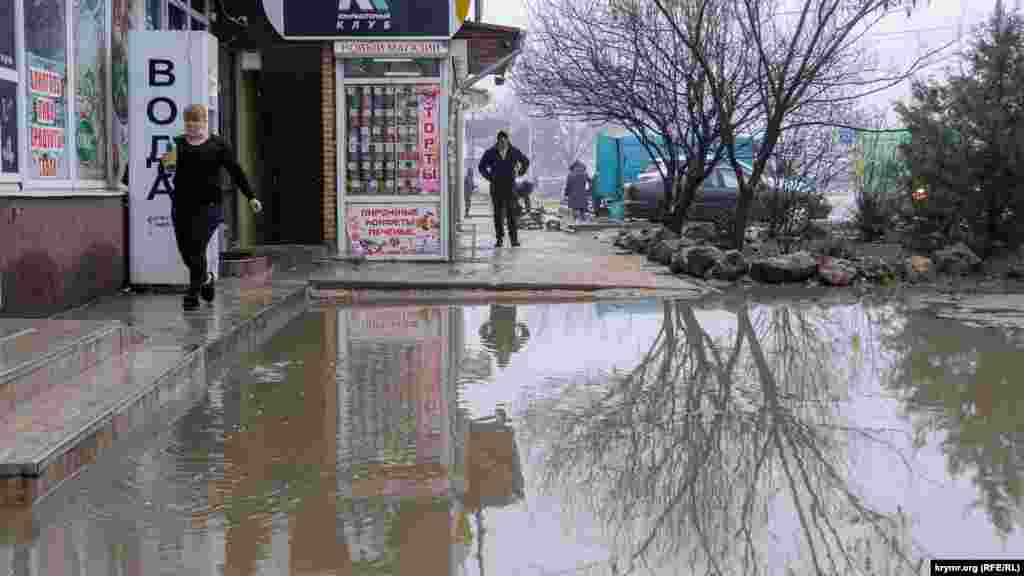 Торговые точки в окружении большой лужи на улице Киевской, рядом с рынком «Крымский Привоз»