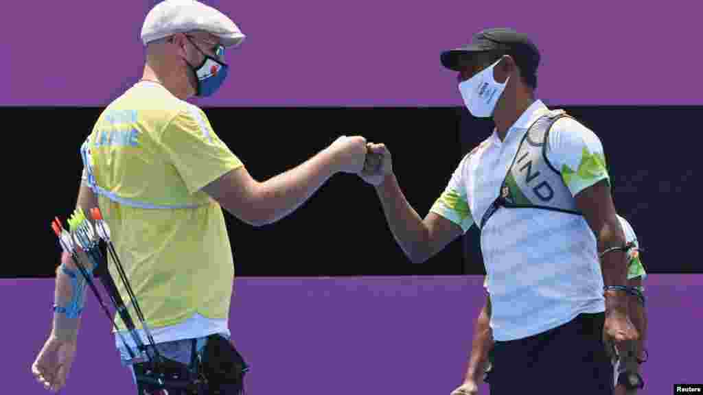 «Ковідне» вітання українця Олексія Гунбіна та Тарундіпа Рая з Індії після поєдинку зі стрільби з лука, чоловіки, 1/32 фіналу під час Олімпійських ігор в Токіо, 28 липня 2021 року  