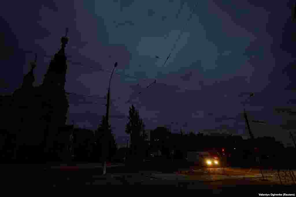 Мікроавтобус проїжджає темною вулицею Миколаєва. Фото від 20 жовтня. Російські атаки на українську енергомережу призвели до загальнонаціональних відключень електроенергії 20 жовтня, погіршивши ситуацію, в якій опинилися українці. Ймовірно, на людей через війну чекає зима без достатньої кількості електроенергії та тепла  