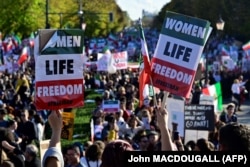 Protesters display placards reading "Women, Life, Freedom" at a rally in support of the demonstrations in Iran following the death of Mahsa Amini, in Berlin on October 22, 2022.