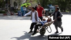A wounded man is carried away from the site of a deadly twin bomb attack in Kabul, which killed at least 25 people on April 30.