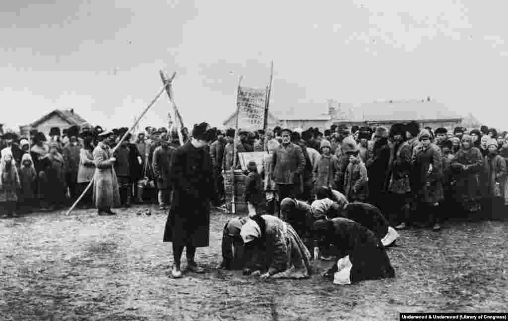 Голодные женщины становятся на колени перед сотрудником гуманитарной миссии США, 1922 год. Большевики побеждают после 5 лет яростных сражений 
