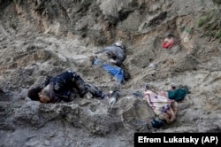 Чотири тіла у братській могилі, в тому числі старости села Мотижин Ольги Сухенко, її чоловіка і сина, які були вбиті військовими Росії, квітень 2022 року