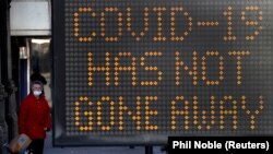 پر برتانیا کې د سړک پر غاړه پر لګېدلې لوحې لیکل شوي چې د کورونا وایرس ناروغي لا هم موجوده ده - د ۲۰۲۱ز کال د ډېسېمبر ۱۸مې انځور