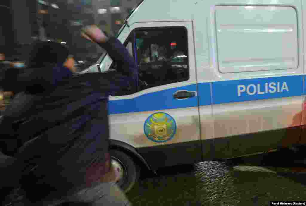Protesters attack a police van in Almaty as protests turned violent overnight on January 4-5. Police vehicles were set ablaze, and multiple arrests made. 