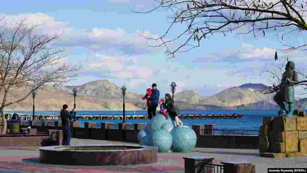 Семья фотографируется на «Облачке счастья»: шести керамических шарах, которые установлены перед памятником поэту Максимилиану Волошину