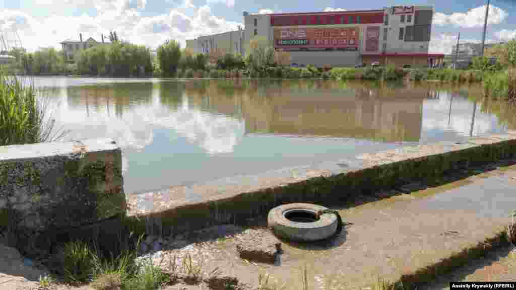 Переполненный дождевыми стоками Сергеевский пруд на реке Абдалка (ранее называлась Боурча) у объездной Ялтинской автотрассы перед торгово-развлекательным центром «FM»