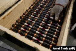 Radnik u BiH slaže praznu municiju u kutiju.