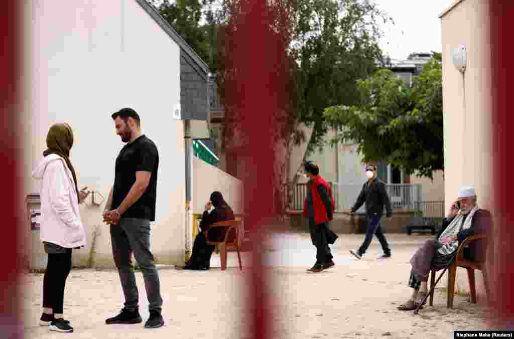 Afghan refugees Asma Halimi, 25, and Mohammad Omer Aiuby, 29, talk in the courtyard at the Razay reception center on August 30 in Piriac-sur-Mer, France, following their evacuation from Afghanistan the previous week.