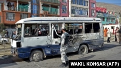A security personnel visits the site of a blast in Kabul on March 18 that hit a bus carrying government employees.