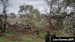 Нацгвардійці підходять до пошкодженого російського танка, на який вивісили український прапор, після звільнення Харківщини. Вересень 2022 року