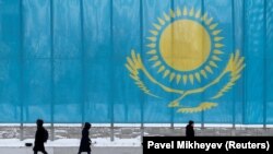 Люди проходять повз прапор Казахстану в Астані (фото ілюстративне)