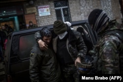 Український солдат допомагає товаришові біля лікарні в Артемівську, 2 лютого 2015 року.