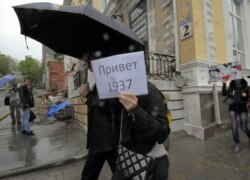 Учасники протесту проти режиму Володимира Путіна прогулюються з плакатами. Напис на плакаті «Привіт 1937 рік» нагадує про смертельний рік репресій радянського диктатора Йосипа Сталіна. Владивосток, 12 червня 2012 року