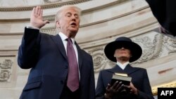 Дональд Трамп приносит присягу в качестве 47-го президента США перед председателем Верховного суда Джоном Робертсом, а Мелания Трамп держит Библию во время 60-й инаугурации президента в ротонде Капитолия США в Вашингтоне, 20 января 2025 года