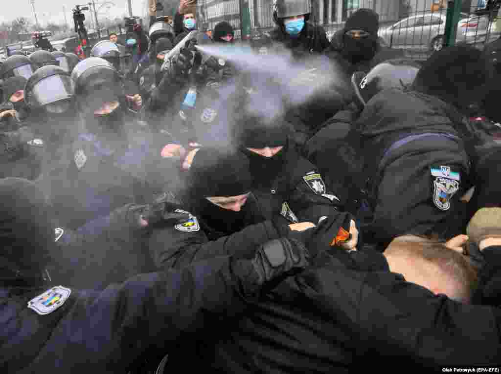 Столкновения в Киеве возле телеканала «НАШ» между силами безопасности и протестующими, которые обвиняют вещатель в трансляции российской пропаганды. (epa-EFE / Олег Петрасюк)