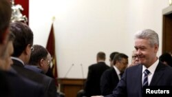 First Deputy Prime Minister Sergei Sobyanin (right) shakes hands with deputies of the United Russia party as he arrives to take part in a session of the Moscow City Duma on October 18.
