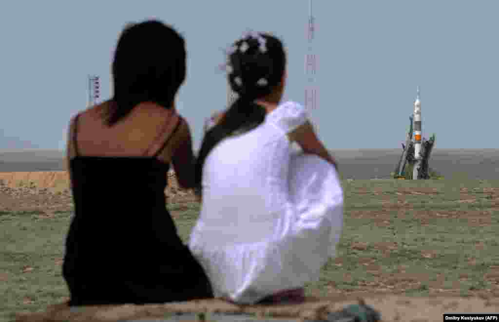 Казашки смотрят на приготовления к старту в 2009 году. Пока Россия преодолевает коррупцию при создании космодрома «Восточный», а США начинают программу запуска астронавтов к МКС на ракетах SpaceX (запуск был перенесен), старая казахская стартовая площадка уходит в прошлое. Что будет с населением города, которое ее обслуживает, пока непонятно  