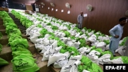 Співробітники ЦВК Пакистану розподіляють мішки з бюлетенями перед загальними виборрами в тій країні.