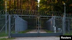 Окруженный колючей проволокой въезд на объект Старые Кейкуты на северо-востоке Польши