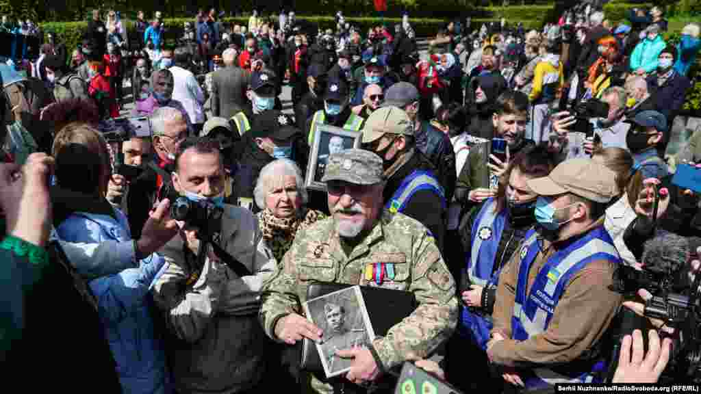 Петро Недзельський, полковник, екс-начальник розвідки 92-ї ОМБр, з портретом батька, ветерана Другої світової війни Дениса Недзельського. З присутніми у нього були словесні перепалки про історію, деякі учасники акції в його бік вигукували «вбивця» і «злочинець»