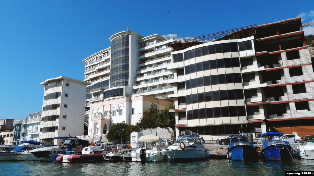 С катера видно многоэтажное здание, местные называют его памятником «жадности века». Капитан судна объясняет, что по проекту это должен был быть отель высотой в три этажа, но застройщик изменил план и возвел десятиэтажное здание. Из-за несоблюдения норм, оно дало трещину и стало разваливаться. Отель так и не запустили в эксплуатацию