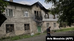 Чоловік стоїть перед своїм будинком, який горить внаслідок обстрілу, Лисичанськ, 5 червня 2022 року