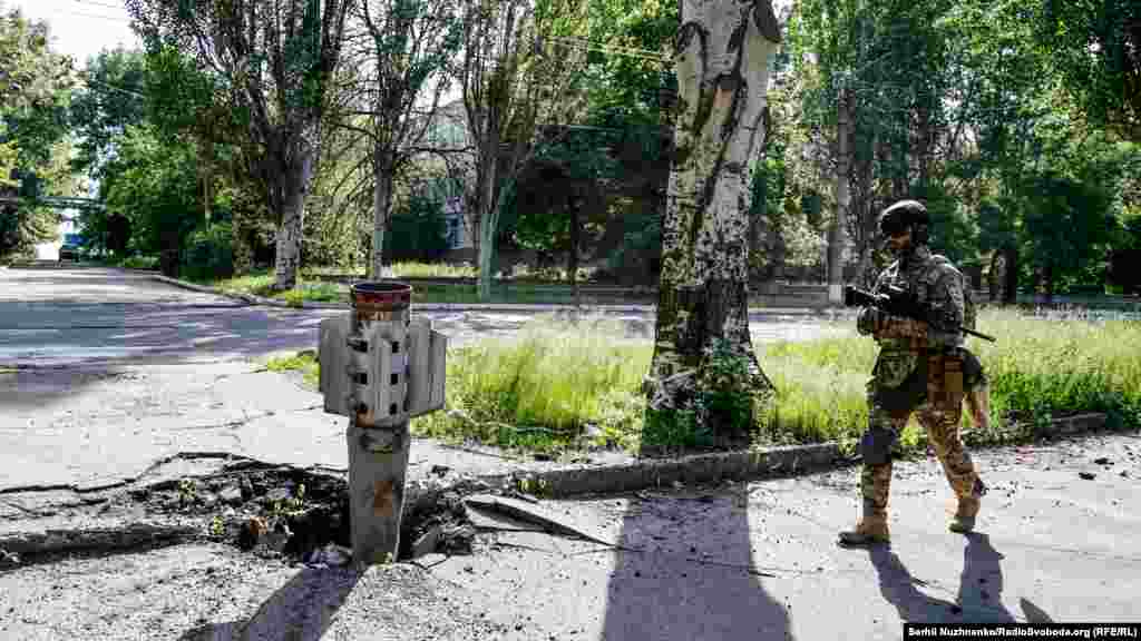 Український військовий проходить повз хвостовик від радянської ракети «Смерч», якими російська армія обстрілює Лисичанськ