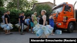 Місцеві мешканці в черзі за водою до водовоза, окупований Донецьк, 29 липня 2025 року