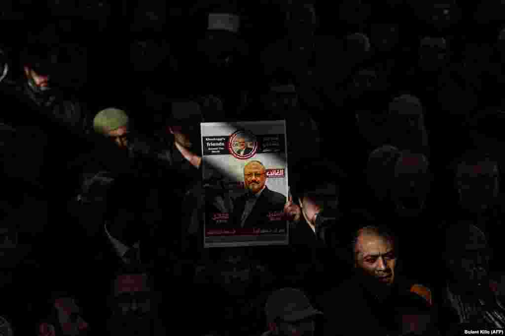 Чоловік тримає фотографію Джамаля Хашокджі під час символічної похоронної молитви за саудівським журналістом у дворі мечеті Фатіх в Стамбулі 16 листопада. Центральне розвідувальне управління (США) дійшло висновку, що вбивство опозиційного саудівського журналіста Джамаля Хашокджі замовив наслідний принц Саудівської Аравії Мухаммед бін Салман. Опозиційний саудівський журналіст, критик саудівської влади та оглядач The Washington Post Джамал Хашокджі був убитий на території консульства Саудівської Аравії у Стамбулі 2 жовтня. За словами державного обвинувача, журналіст був убитий смертельною ін’єкцією, після чого його тіло розчленували. (Bulent Kilic/AFP)