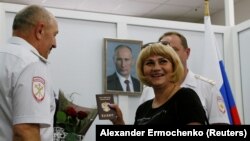 Мешканка окупованої частини Донбасу отримує російський паспорт у відділенні міграційної служби в селі Покровське Ростовської області РФ, 14 червня 2019 року