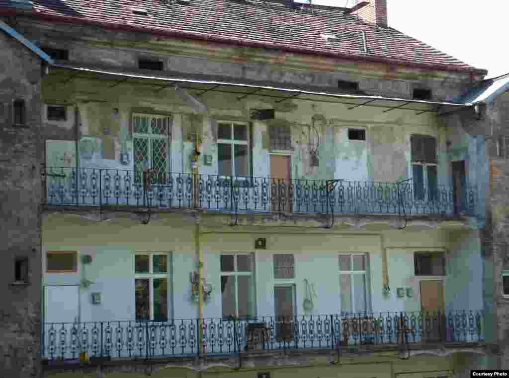 Такой балкон называется "павлач" - это самая характерная особенность жижковской архитектуры. Дома с павлачами  строили на рубеже XIX-XX веков, социальное жилье для небогатых: небольшие квартиры выходили на общую терассу с общими же коммунальными услугами. В Жижкове теперь есть и популярное у студентов кафе "Павлач"; а балконы кажутся милыми историческими пустячками.