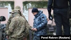 Затриманий український військовослужбовець виходить з мікроавтобуса біля будівлі суду в Сімферополі