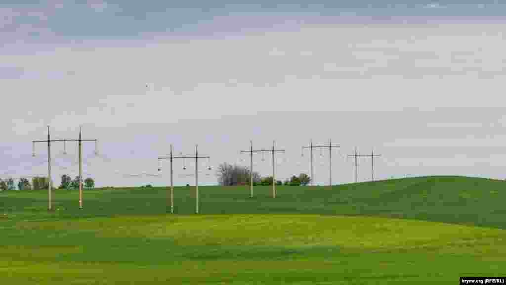 Опоры ЛЭП «шагают» по хлебному полю на восток