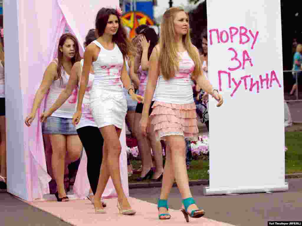 Надев разрисованные майки, девушки выстроились перед журналистами и начали скандировать "Путин! Путин!", ходить кругами и посылать воздушные поцелуи.