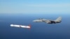 US -- A Tactical "Tomahawk" Block IV cruise missile is escorted by a Navy F-14 