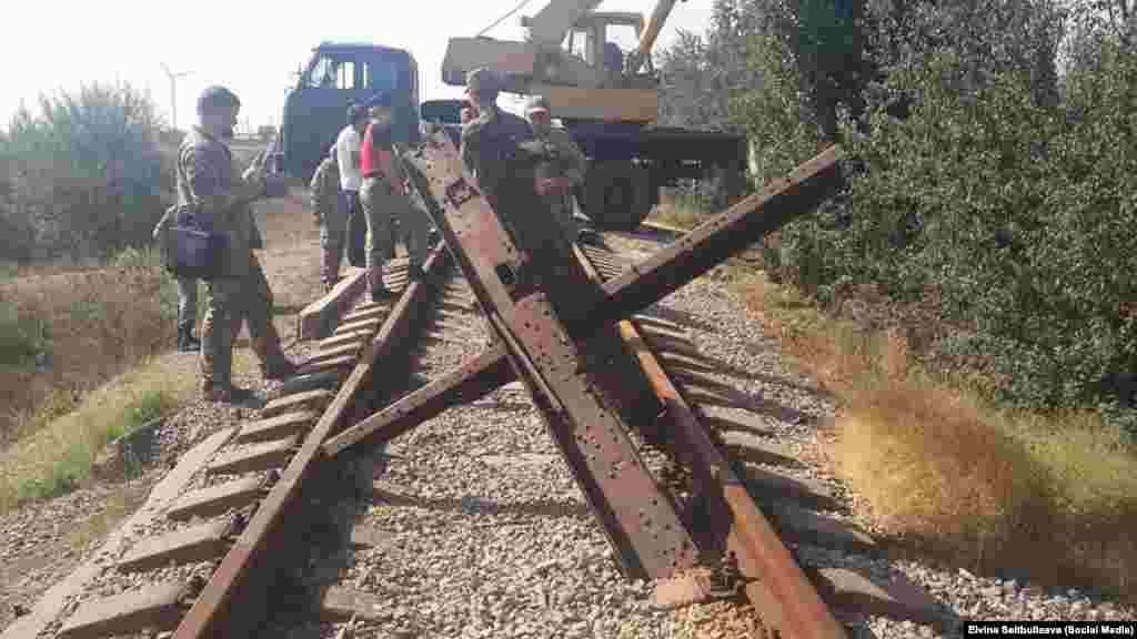 Активісти «кримського майдану» заблокували залізницю, яка веде з Херсонської області на завод «Кримський Титан». До блокади Криму, ініційованої лідерами кримських татар, на завод йшли поставки сировини з континентальної частини України. Херсонська область, 28 вересня 2015 року ЧИТАТИ ПРО ЦЕ