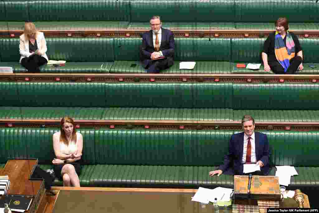 На фотографії, оприлюдненій парламентом Великої Британії, лідер опозиційної Лейбористської партії Кір Стармер (праворуч унизу) й інші депутати Палати громад дотримуються відстані на сесії запитань до прем’єр-міністра 20 квітня 2020 року
