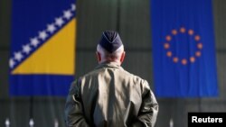 Pripadnik EUFOR-a ispred zastava BiH i EU